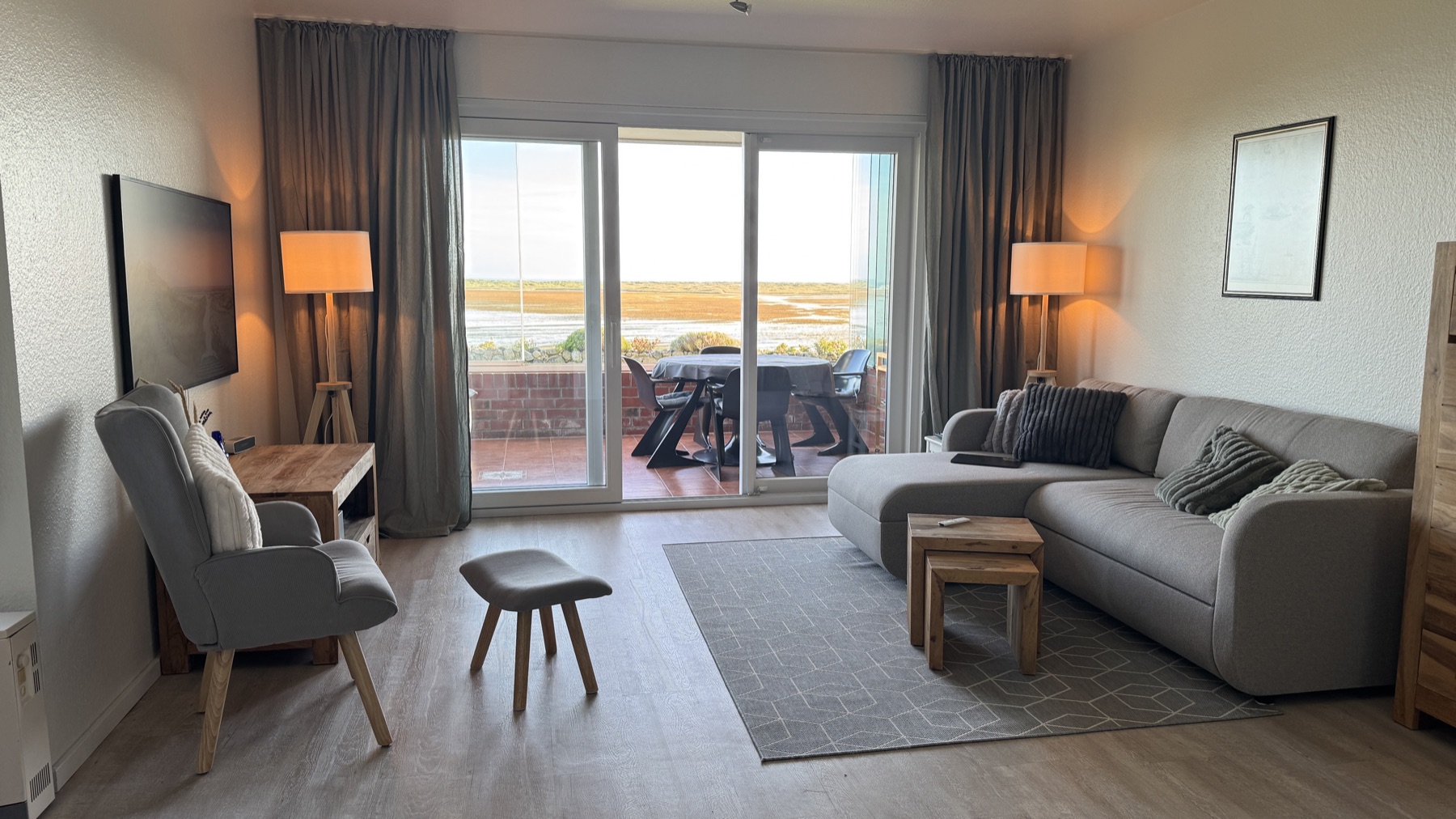 Wohnzimmer mit Sofa und Blick über die Loggia aufs Watt